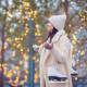 Happy young woman ready to skate on ice rink outdoors